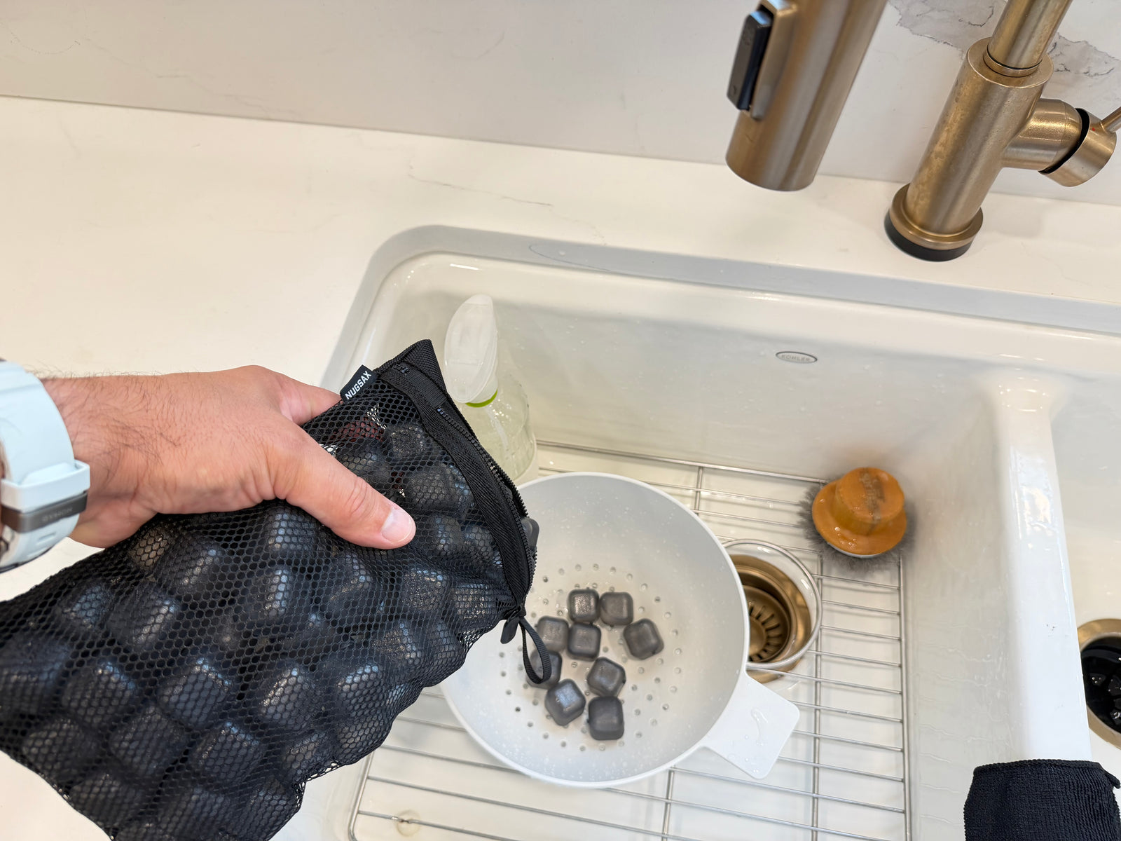 NUGSAX reusable ice cubes being poured into a colander