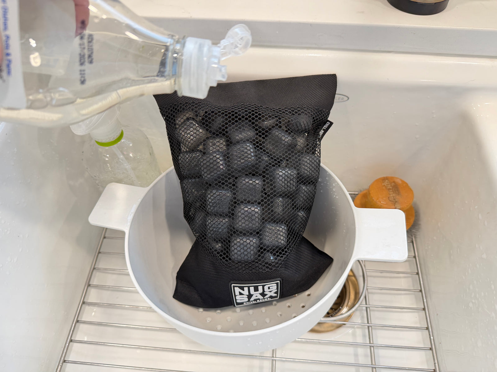 Dish soap being applied to NUGSAX reusable ice cubes inside the bag